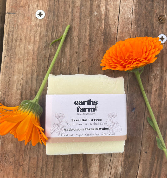 Bar of soap with a label on a wooden surface with orange flowers