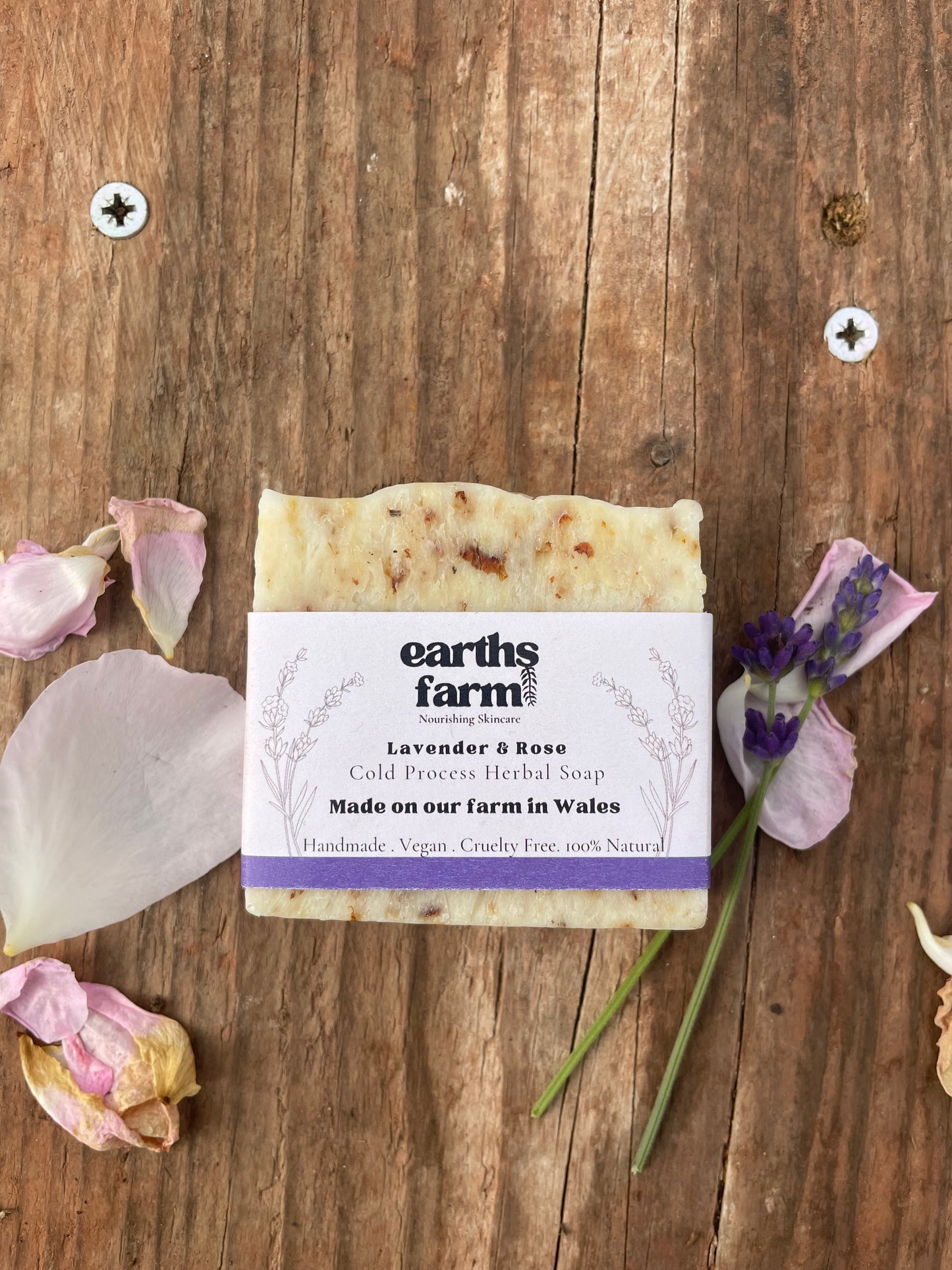Bar of soap with a label on a wooden surface with lavender flowers